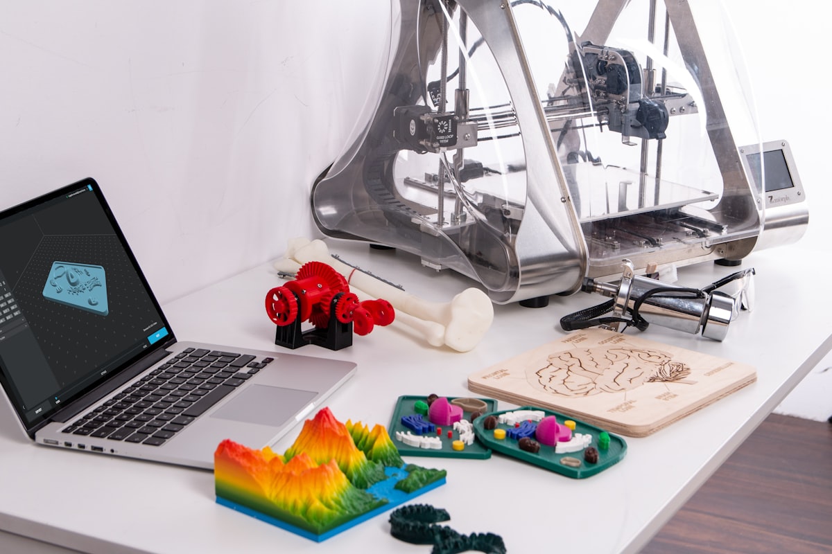 Setup de impressão 3D com laptop e peças coloridas