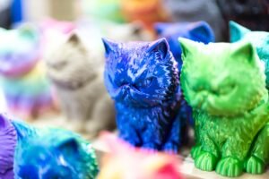 Peças de gatos coloridos impressos em 3D em exposição.