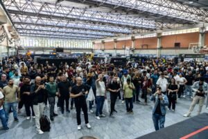 Corredor lotado na Expo3DBR 2026 com visitantes circulando entre estandes de impressão 3D.